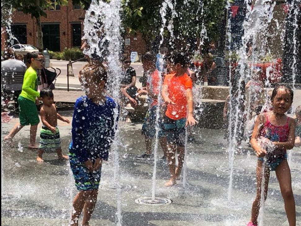 Children playing in a splash pad with water spraying