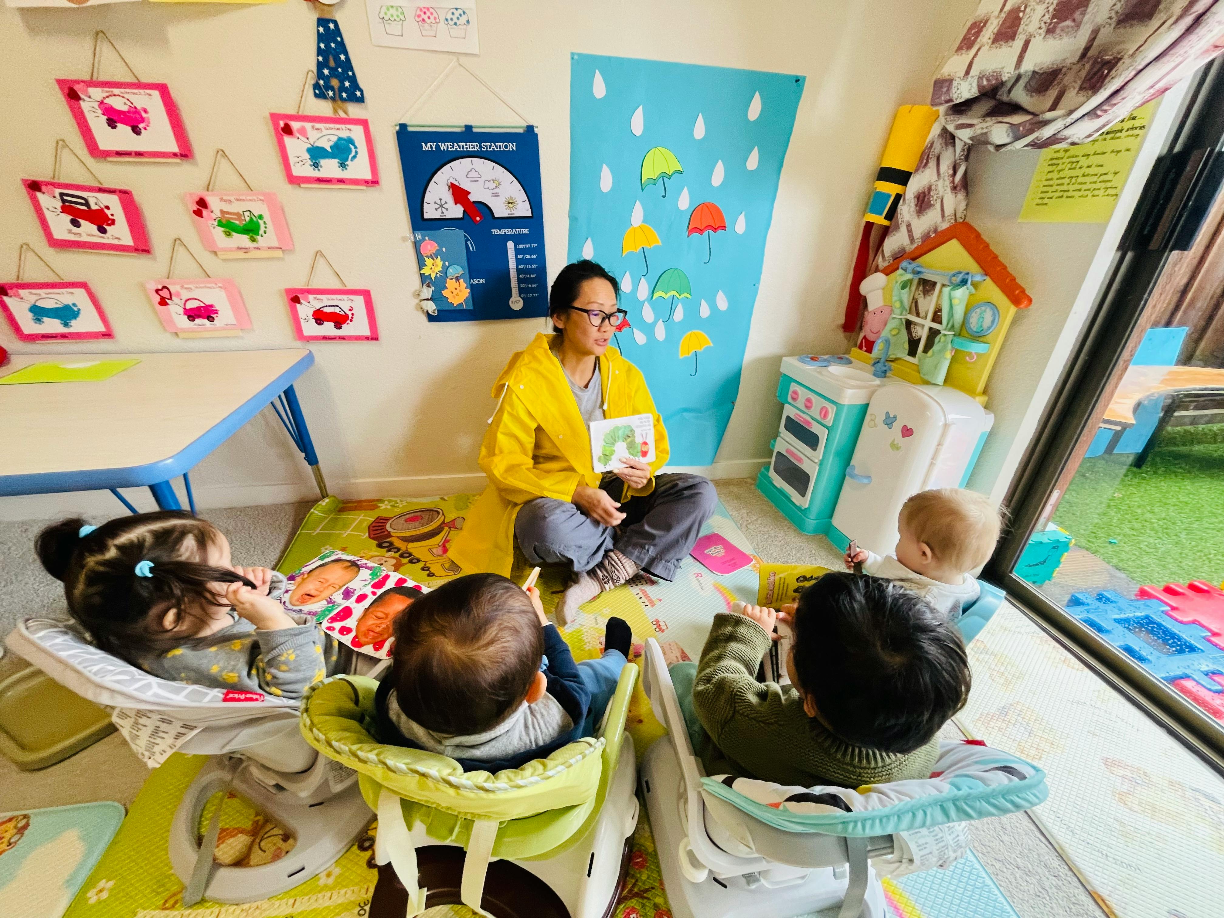 Person reading a book to three children in a classroom