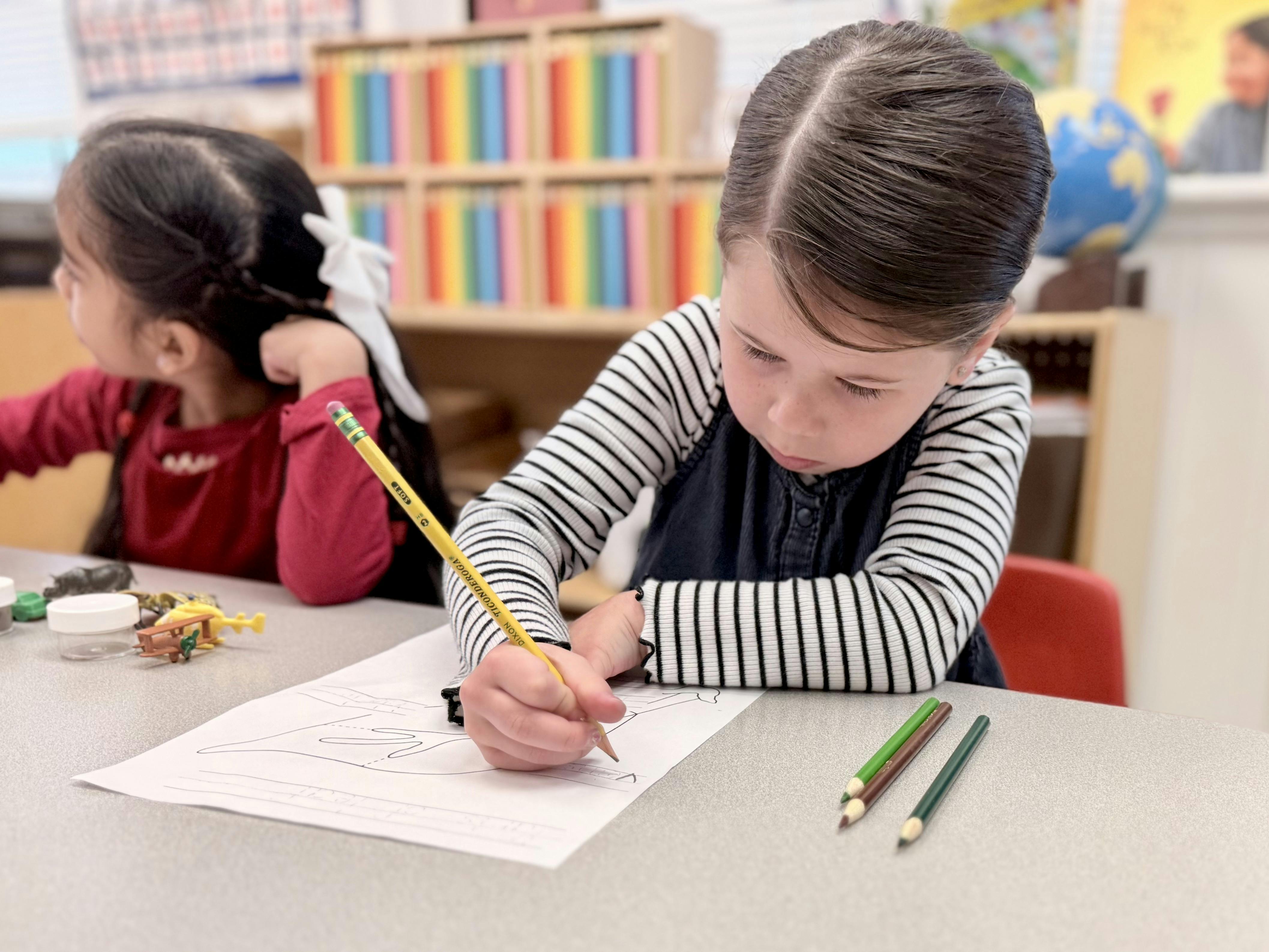 Child writing with a pencil at a desk