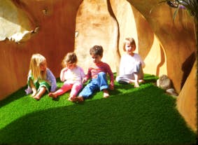 Four children sitting on a grassy slope