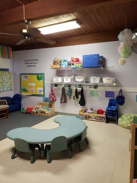 Classroom with a crescent-shaped table and shelves
