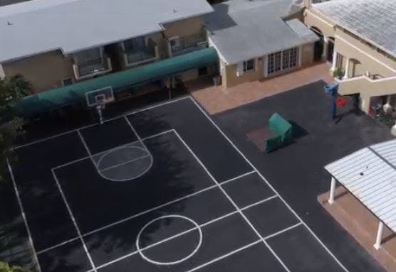 Aerial view of a basketball court next to buildings