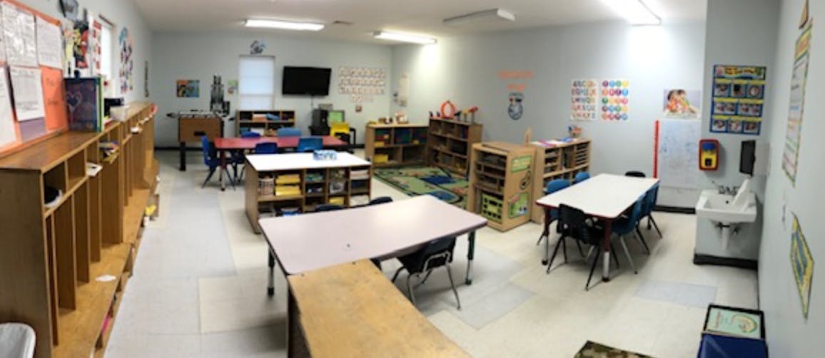 Classroom with tables, chairs, and storage shelves
