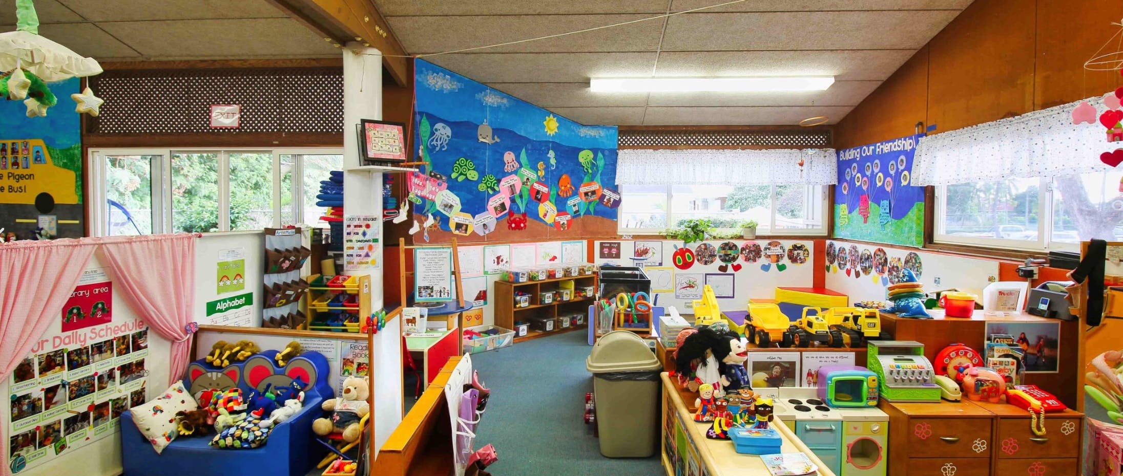 A colorful classroom with toys, decorations, and windows