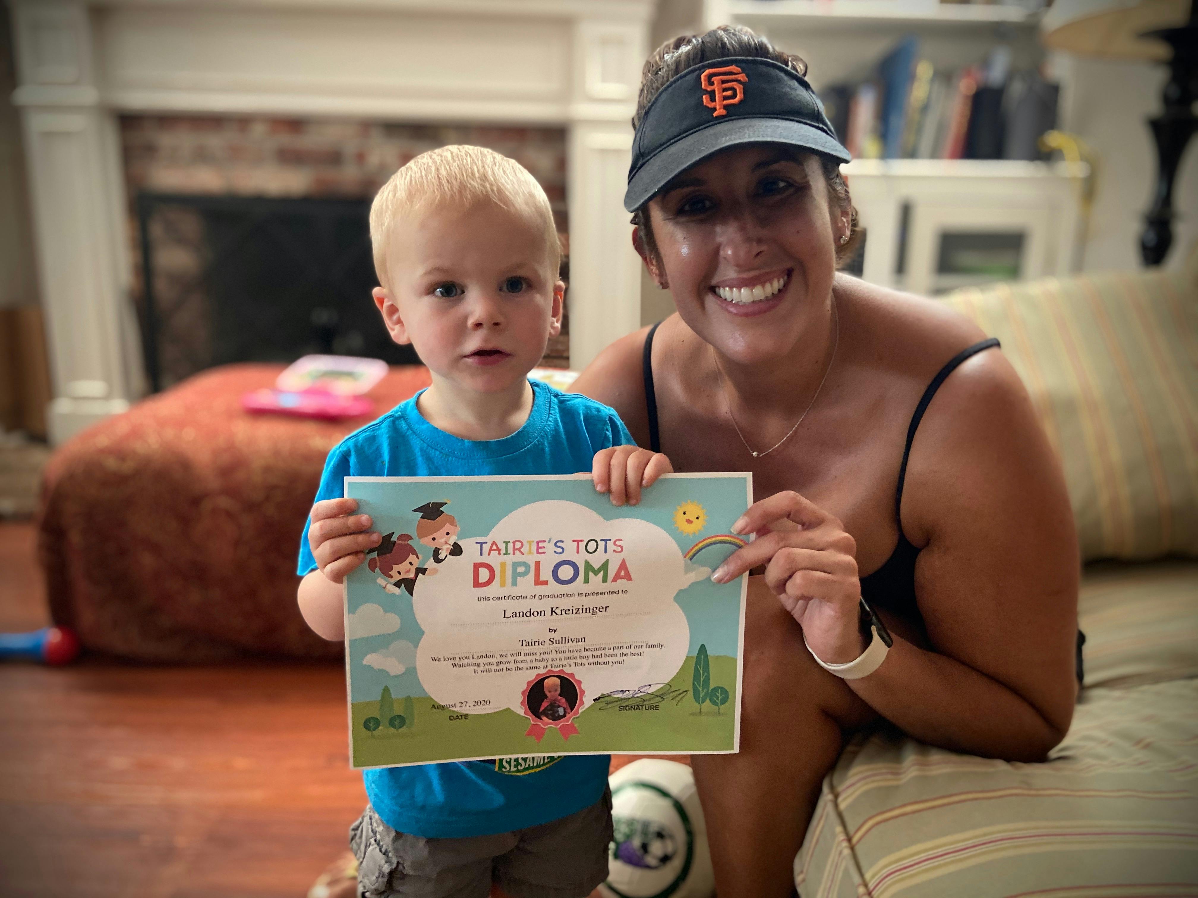 Child and adult holding a Tairie's Tots diploma