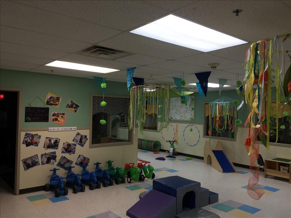 Playroom with small tricycles, soft play equipment, slides, and decorations
