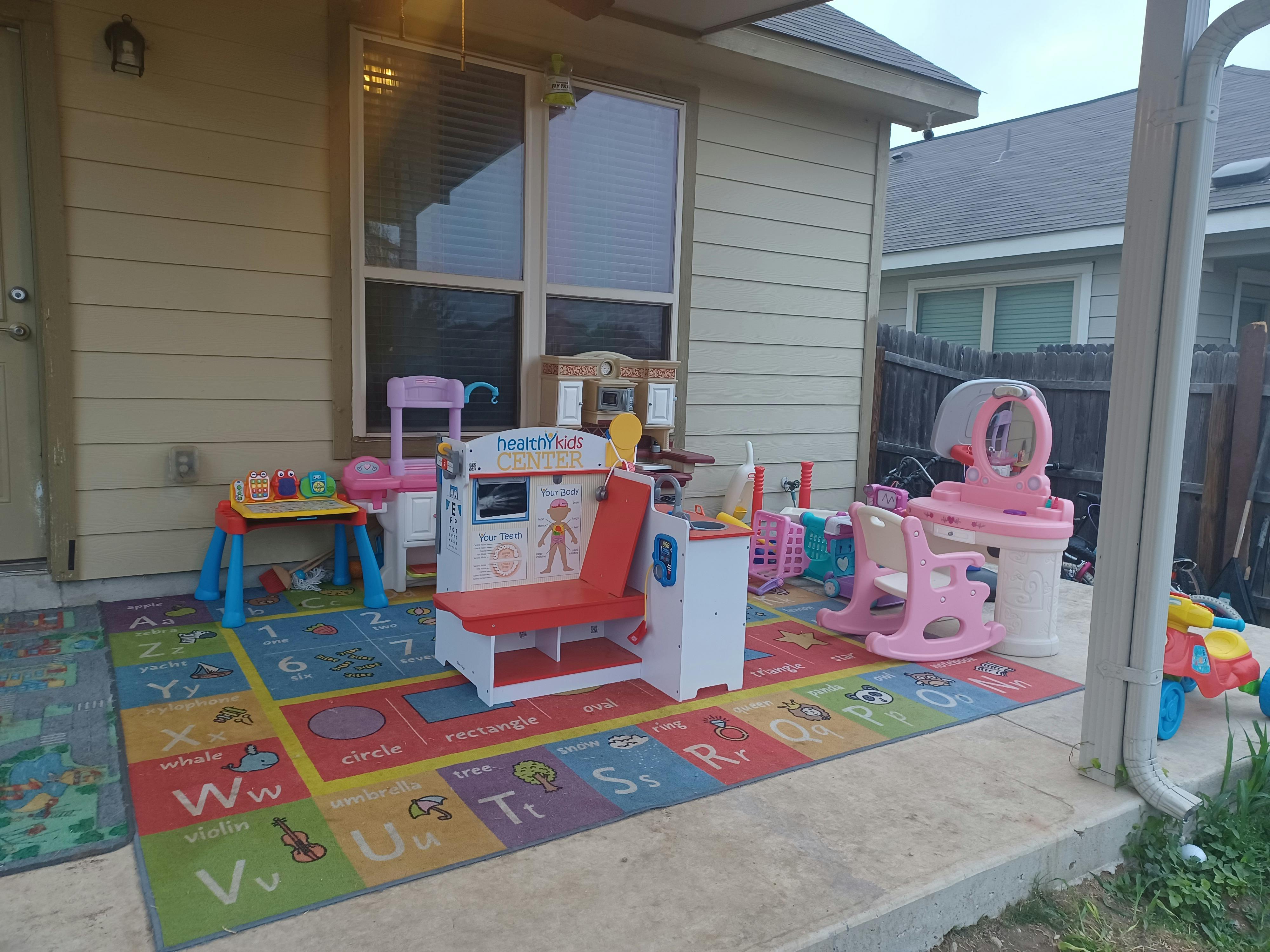Children's play area with a colorful alphabet rug and various toys