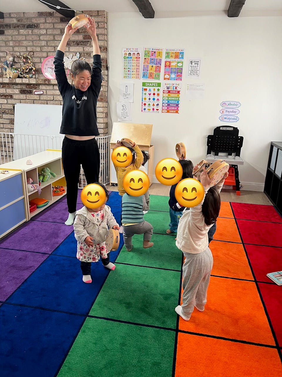 Person holding an object above head with children in a classroom