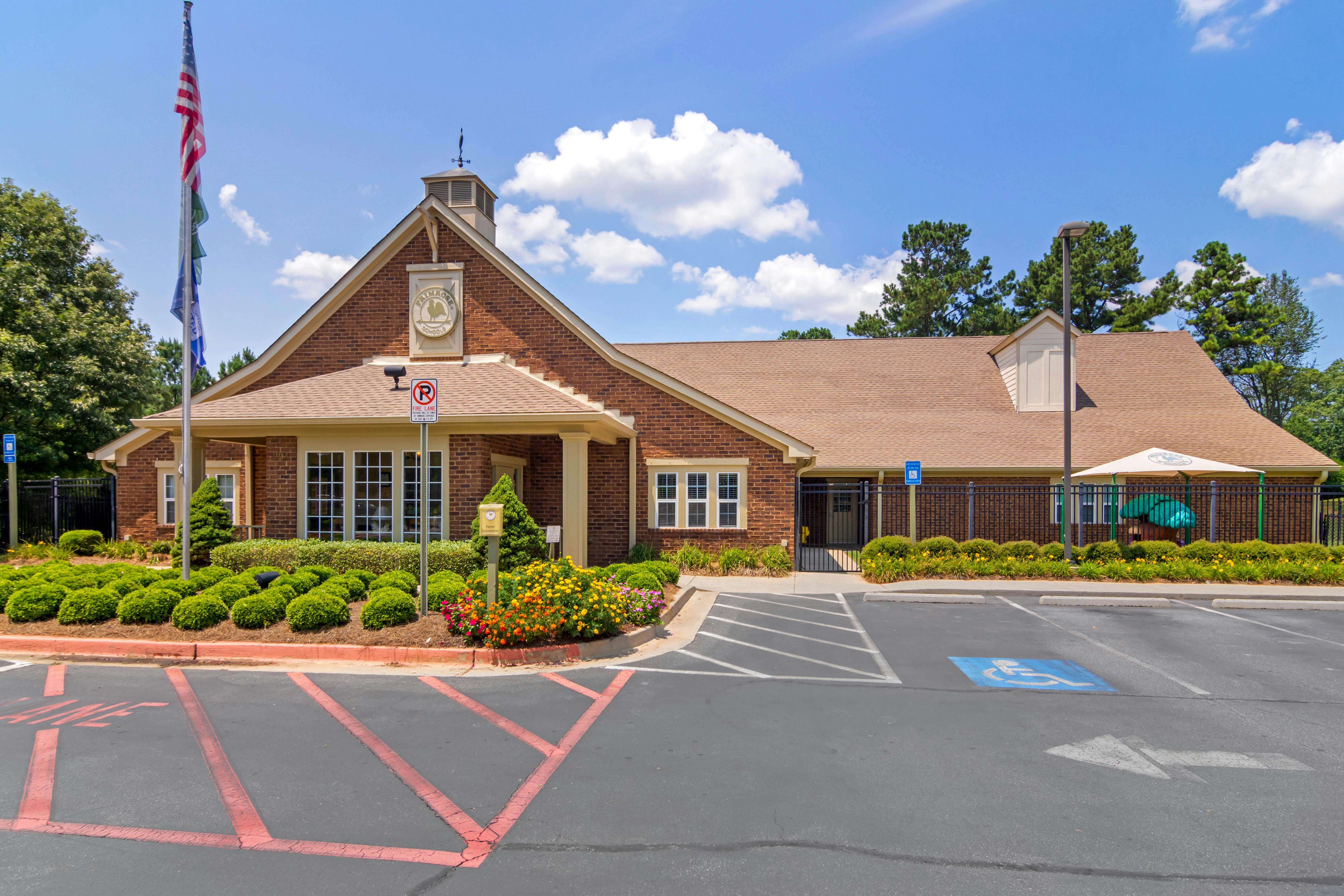 A brick building with a brown roof and a flagpole outside