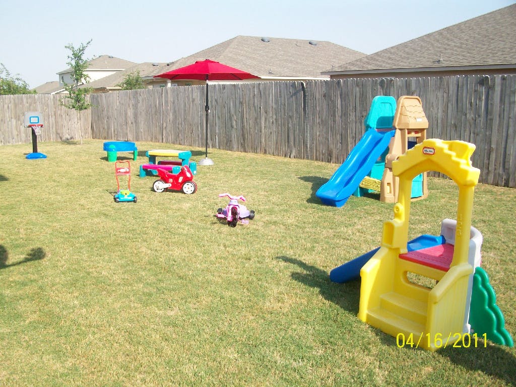 Backyard with playground equipment and ride-on toys