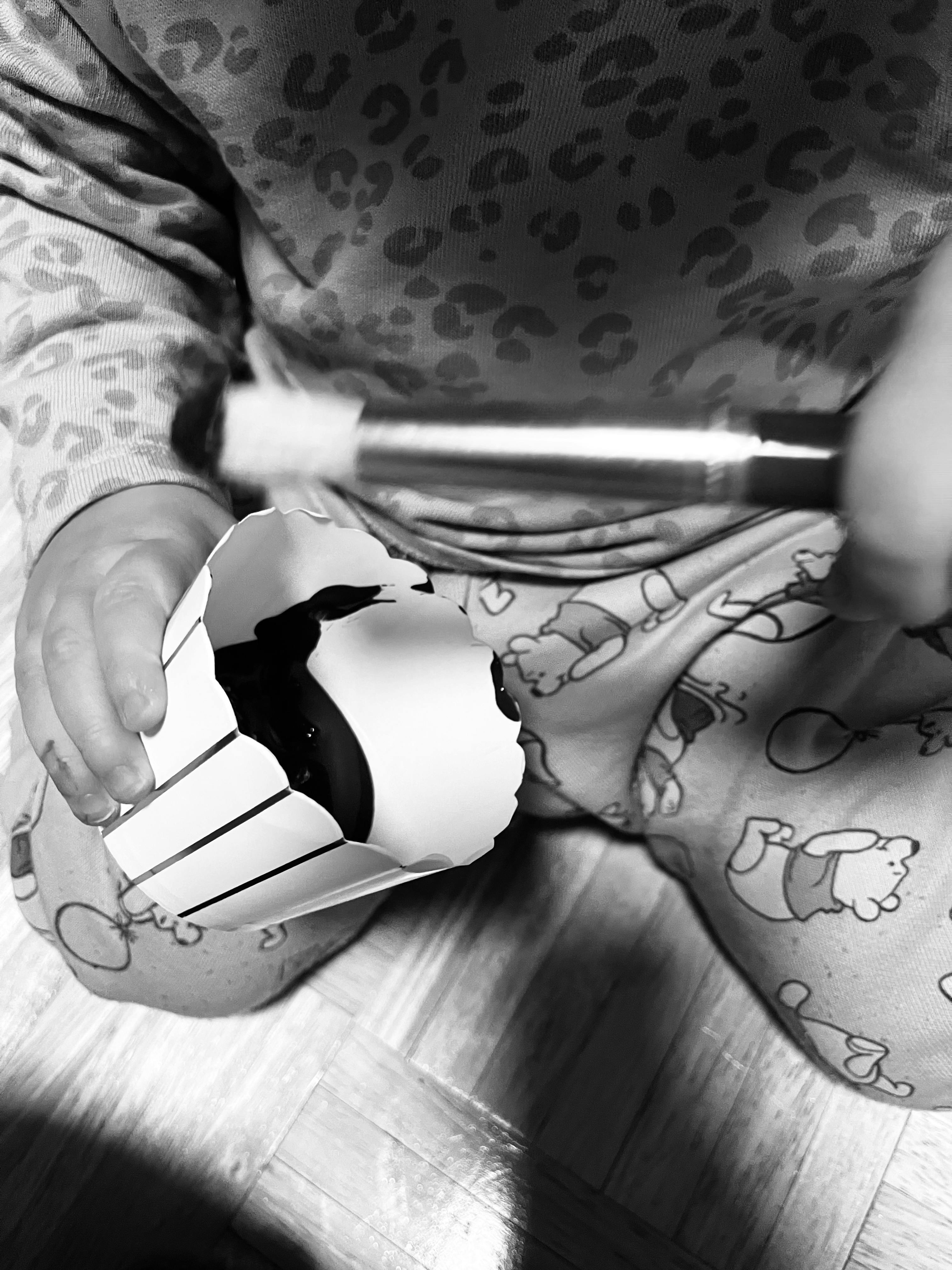 Child holding a paper cup and a paintbrush