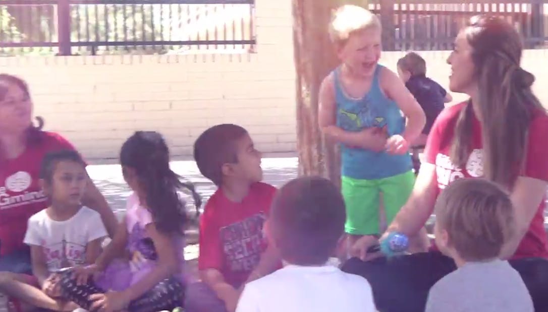 Adults and children sitting and standing outdoors