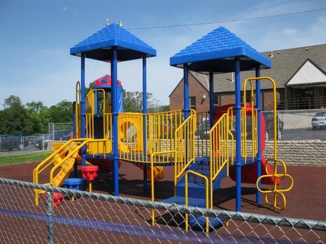 Blue and yellow playground structure with slides and stairs