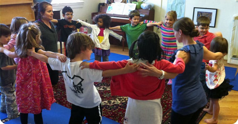 Adults and children standing in a circle with arms linked