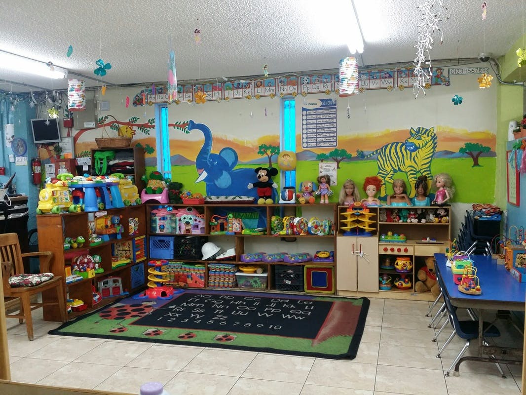 Playroom with shelves of toys, a rug, and a table with chairs