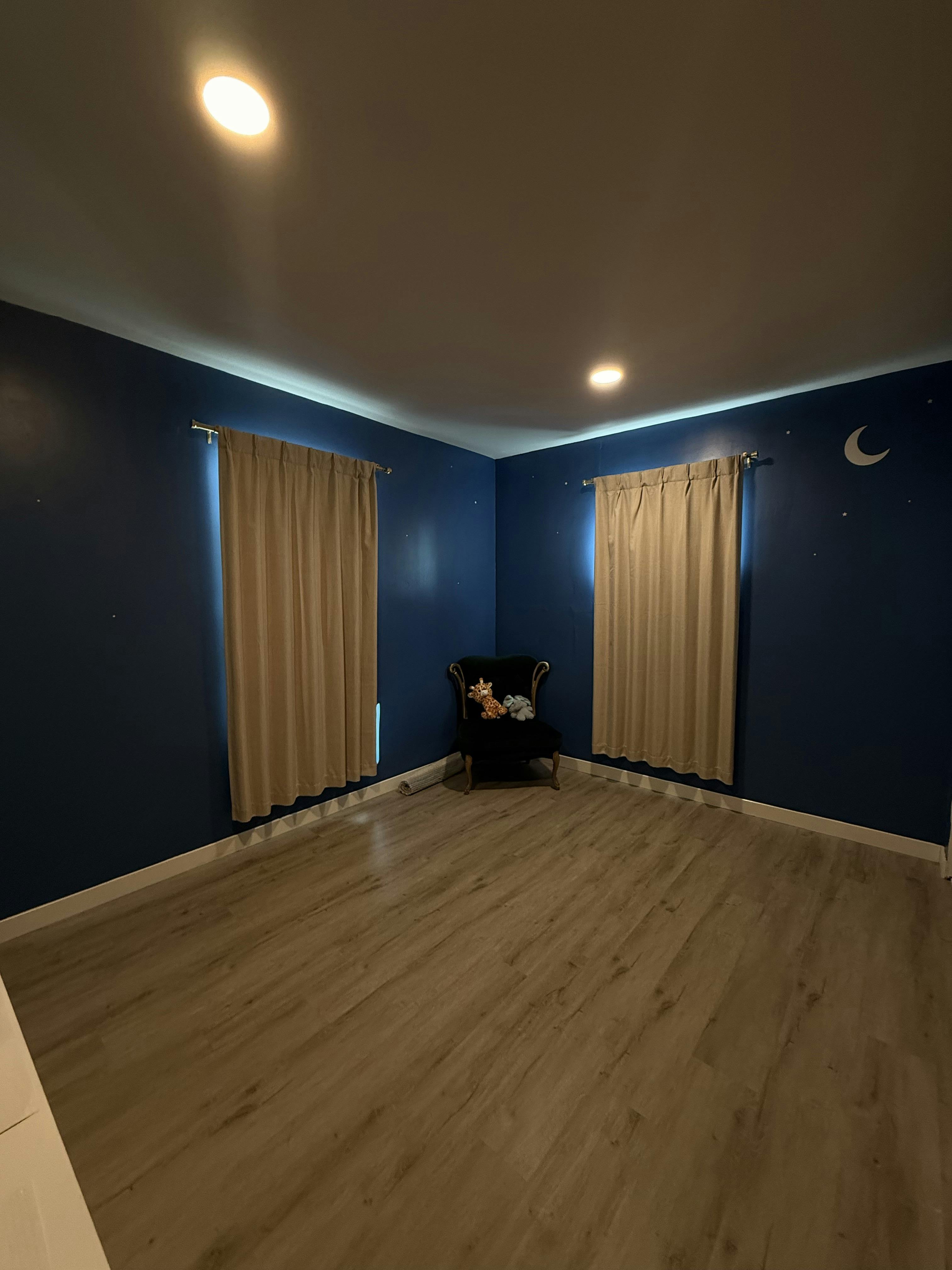 Armchair with stuffed animals in a corner of a blue-walled room