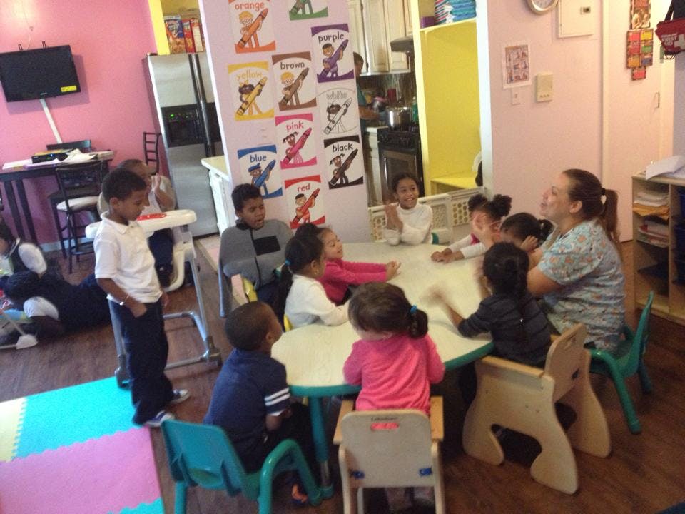 Adult and children sitting around a table in a classroom