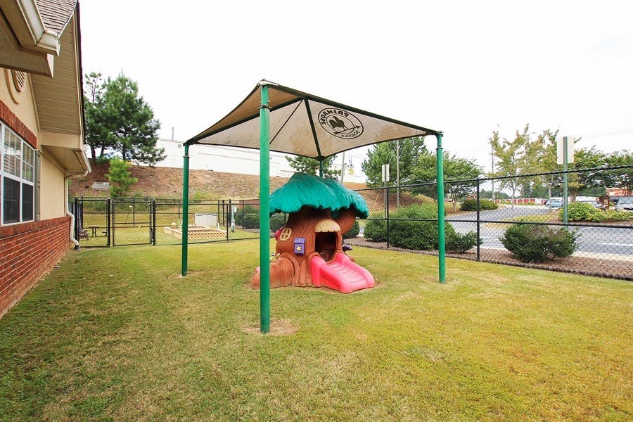 Playground with a small playhouse and slide under a canopy