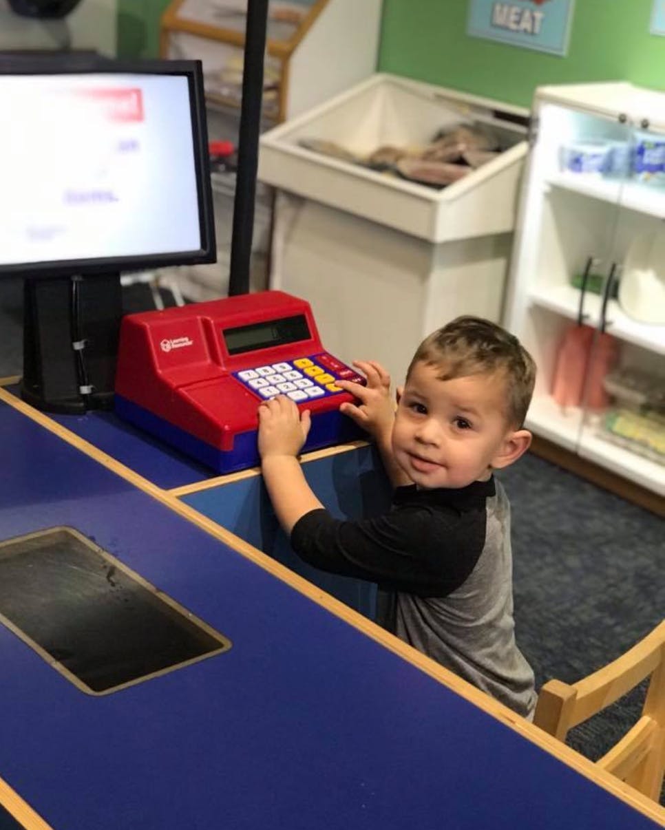 Child playing with a toy cash register