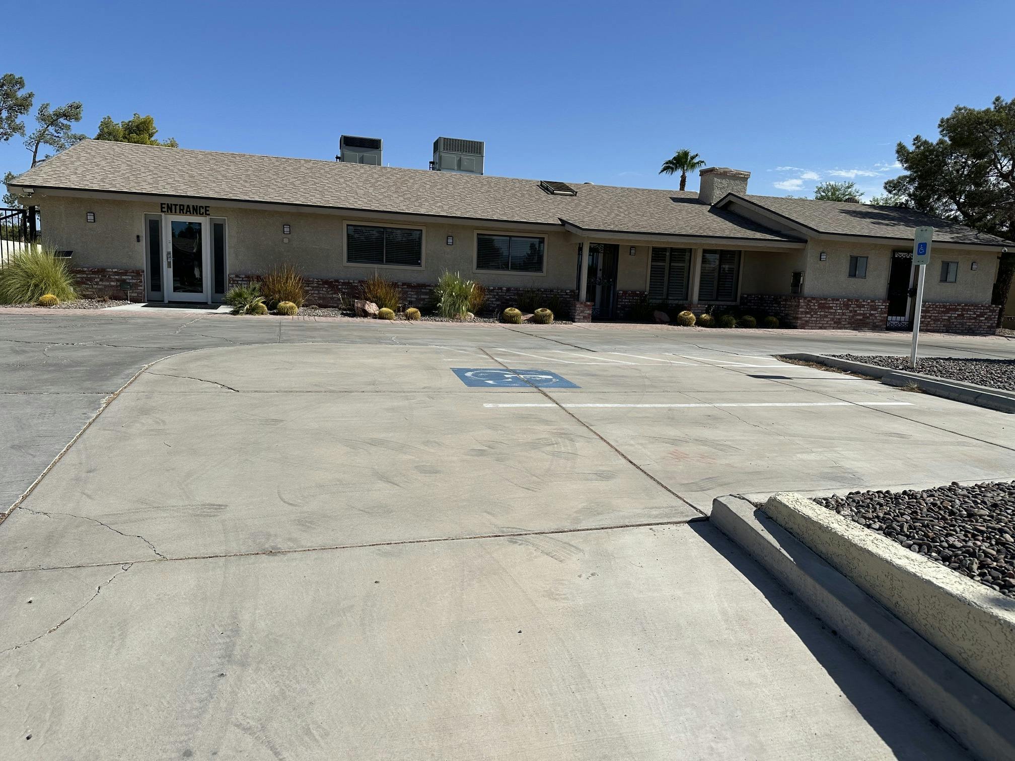 Single-story building exterior with a labeled entrance and parking lot
