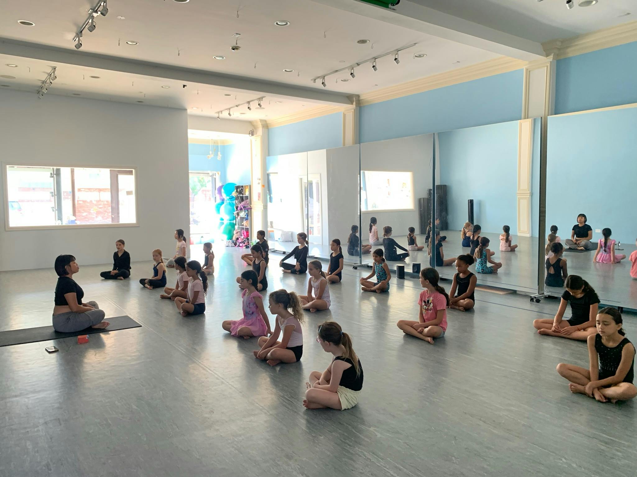 Adult and children sitting on the floor in a studio