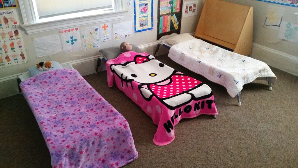 Three cots with blankets in a room