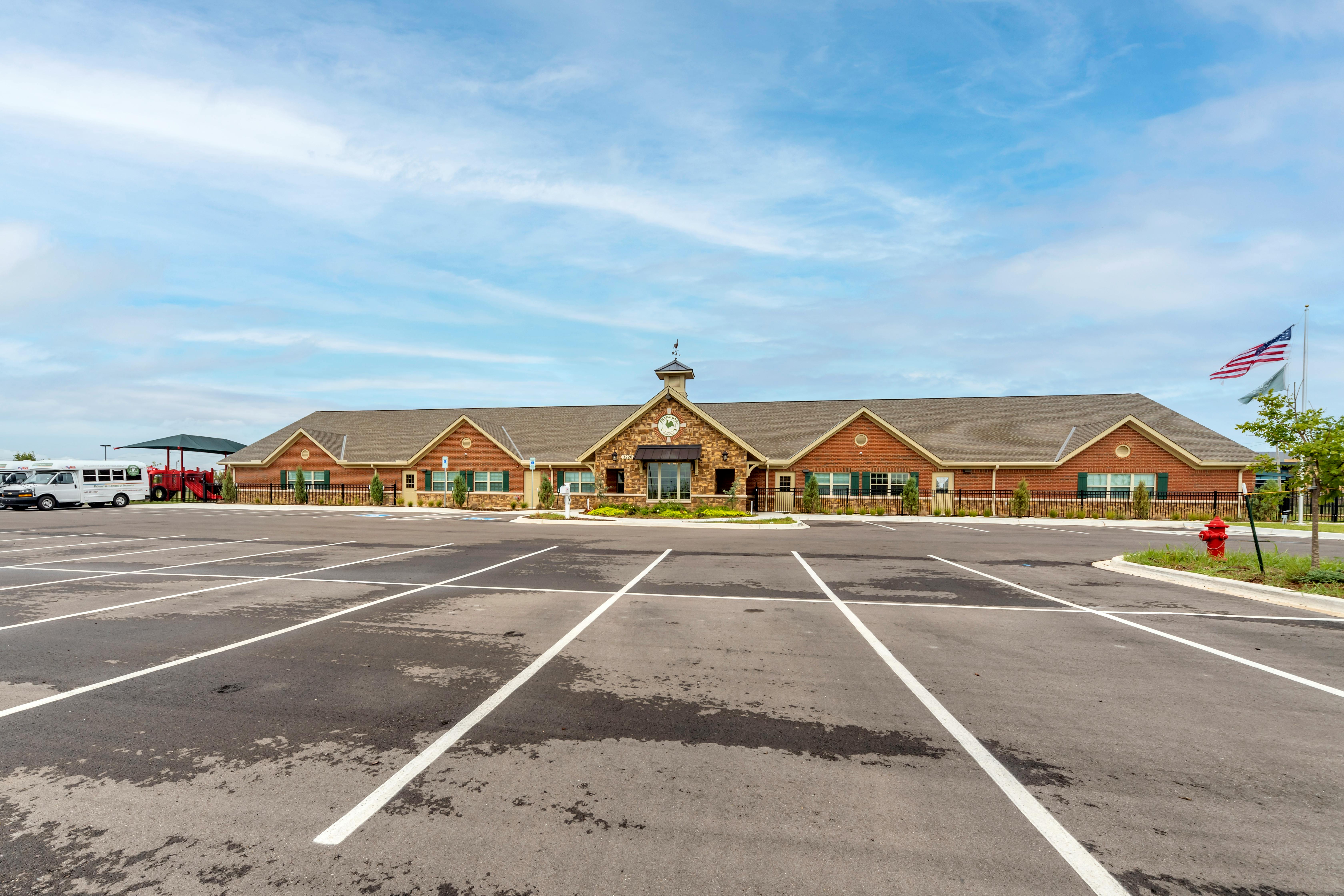 Exterior view of a school building with a large parking lot in front