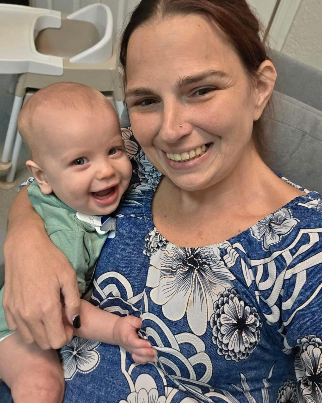 A person holding a smiling infant