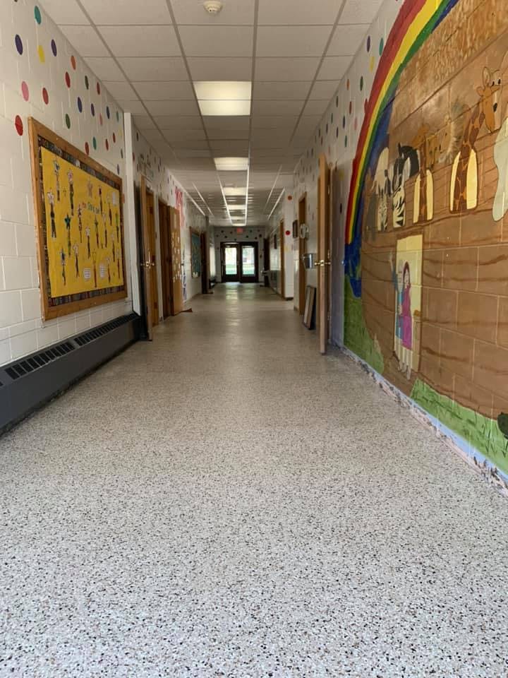 School hallway with bulletin board and mural