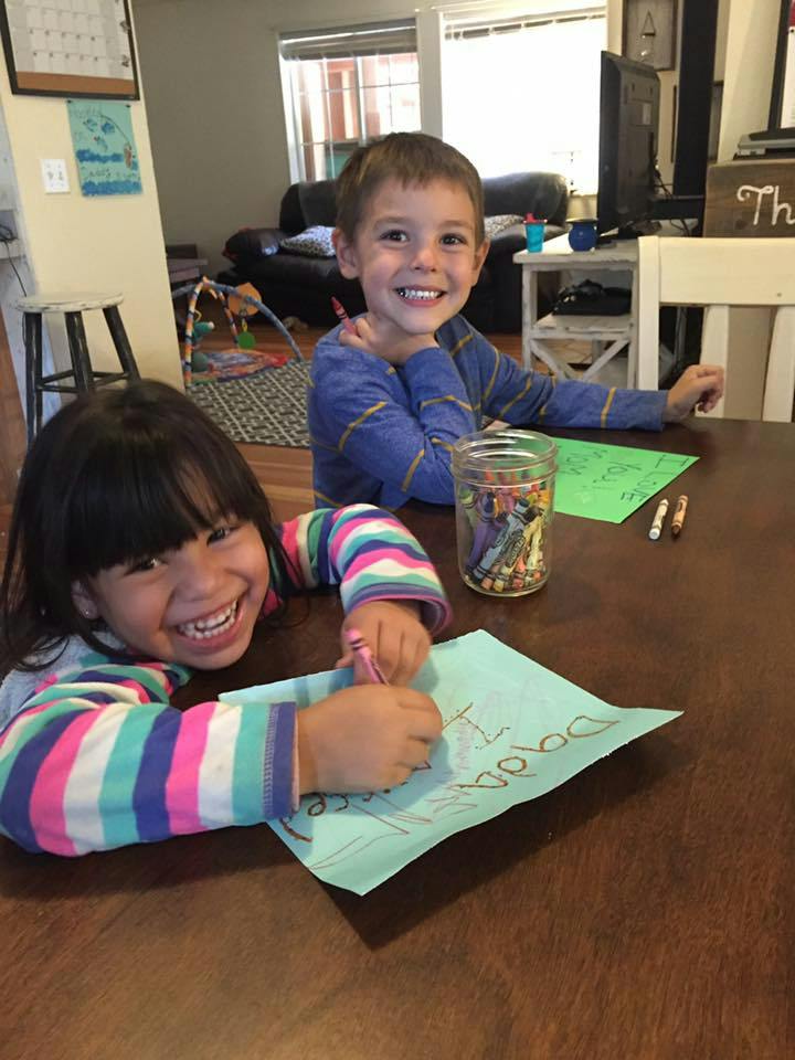 Two children drawing at a table