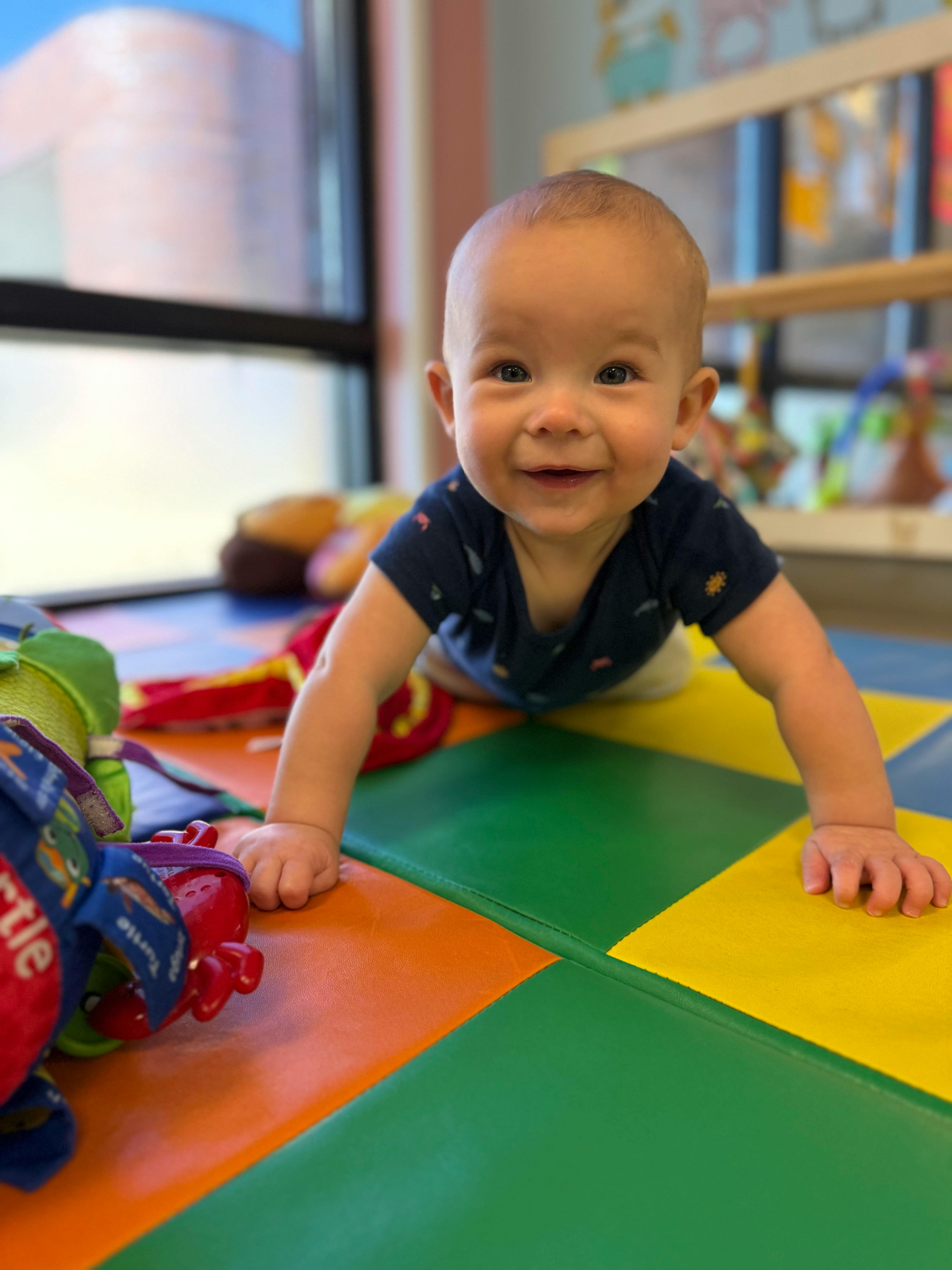 Child crawling on colorful playmat