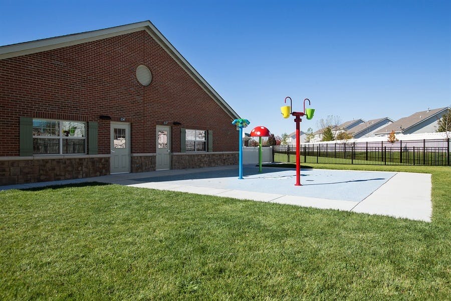 Brick building next to a splash pad with colorful water features