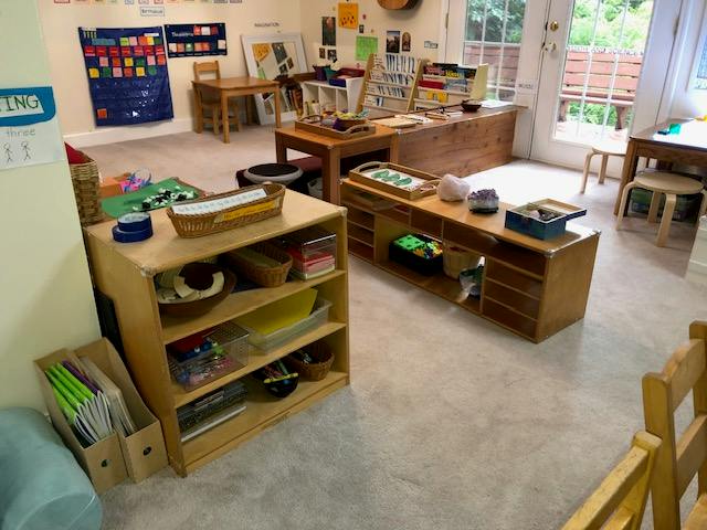 Classroom interior with wooden shelves containing educational materials