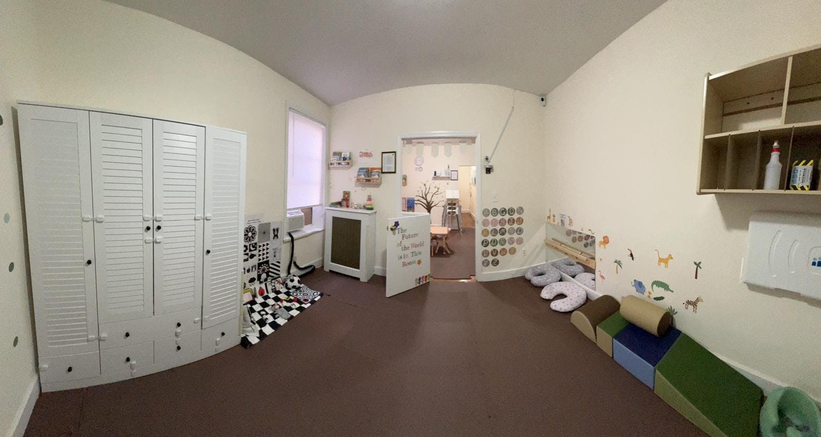 Playroom with white cabinets, brown carpet, and colorful soft play equipment