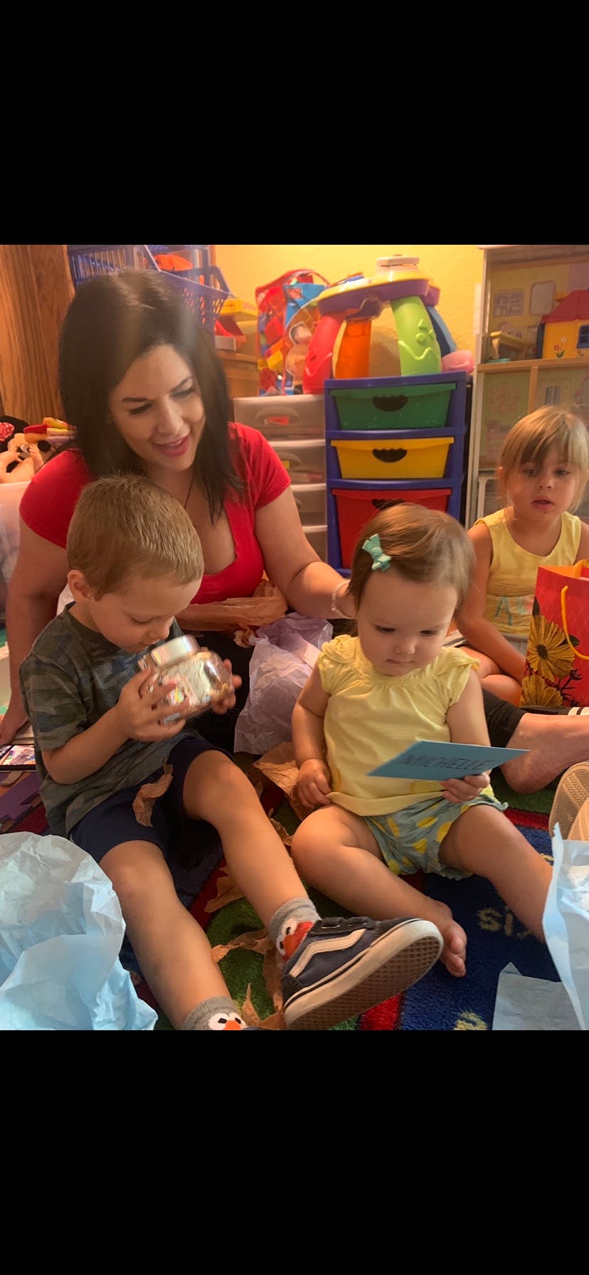Person with three children playing on the floor