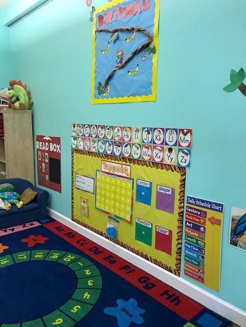 Classroom with bulletin boards, calendar, and alphabet rug