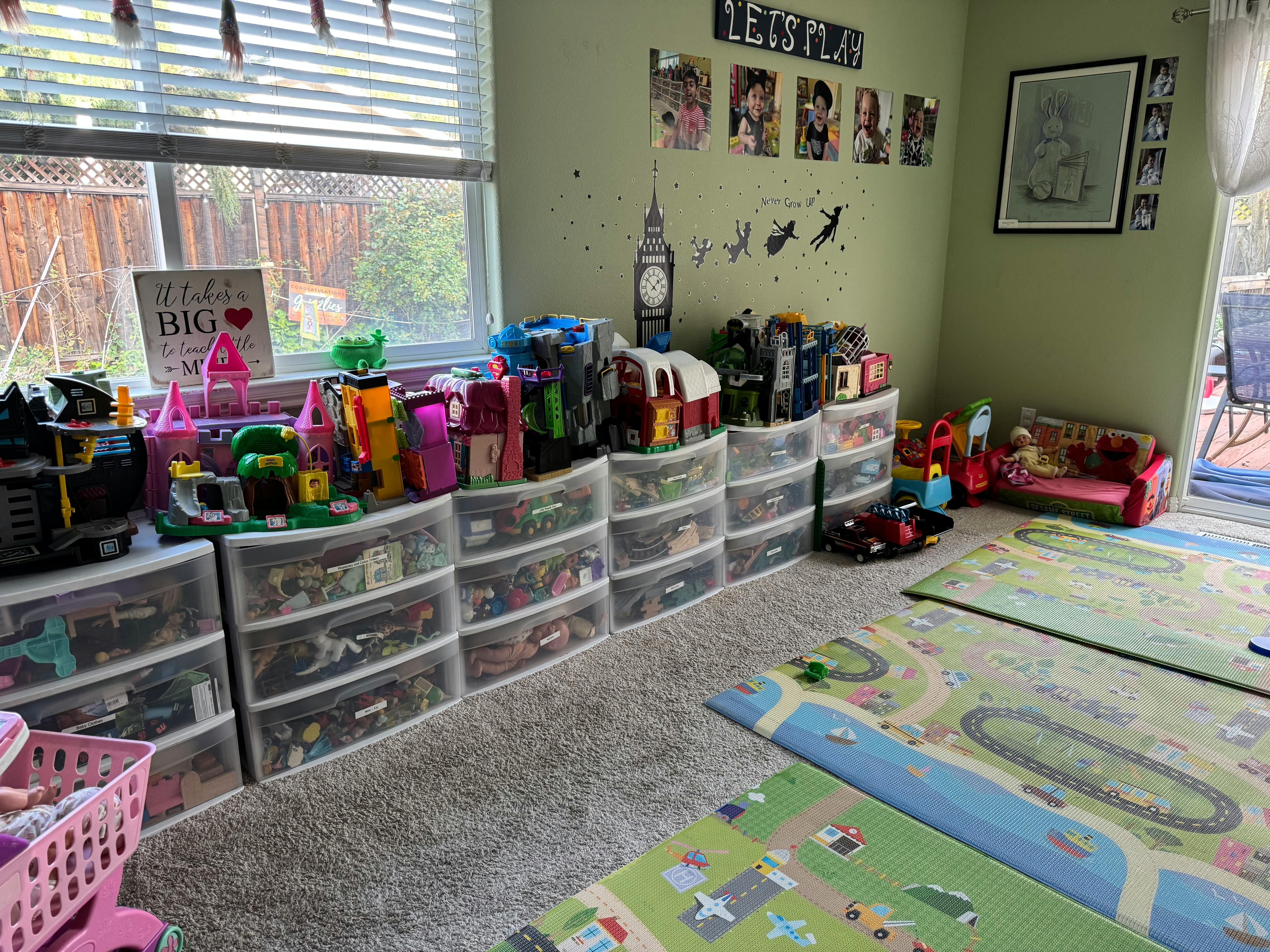Playroom with toy storage drawers, playmats, and window