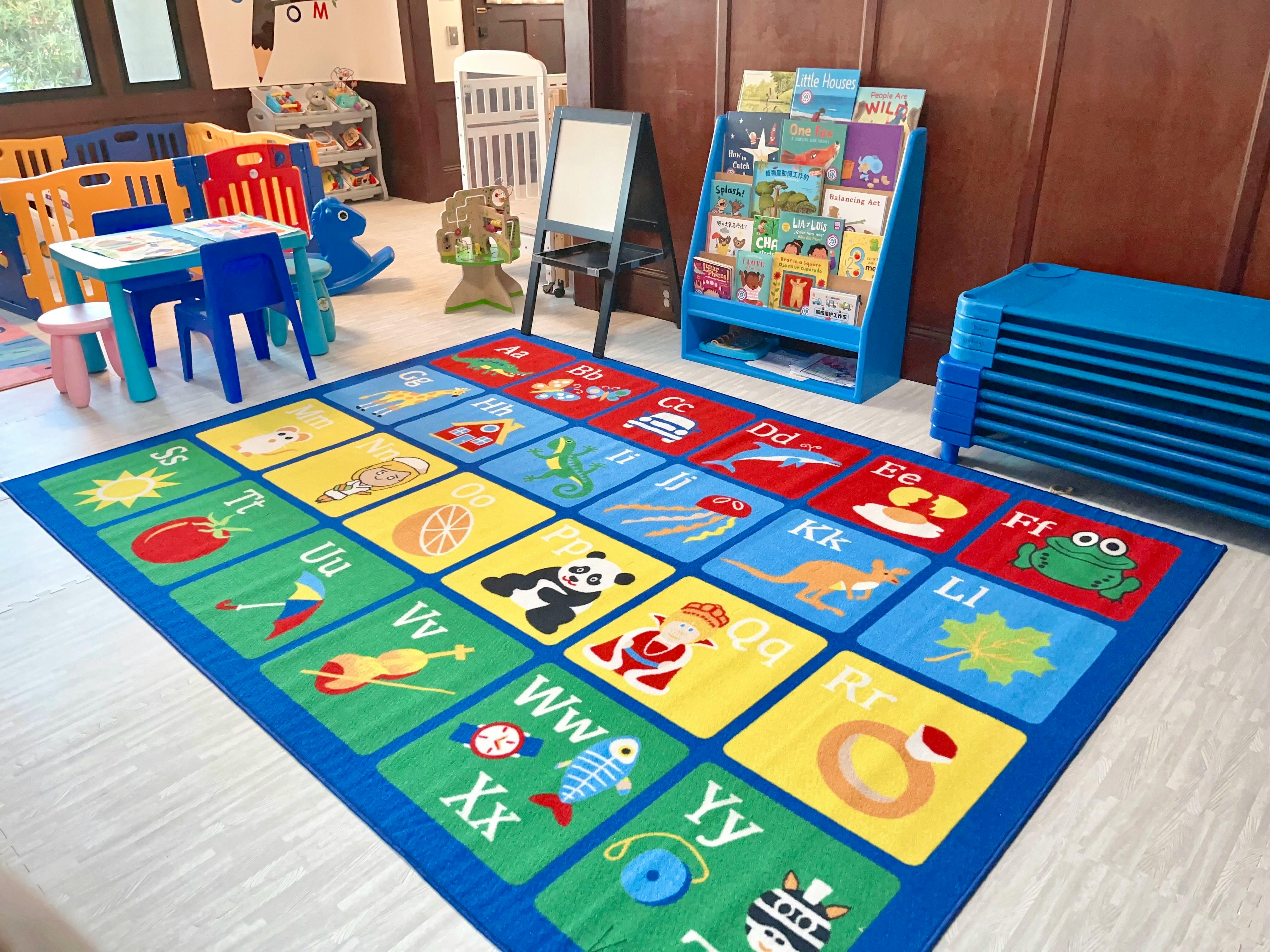 Alphabet rug in a classroom with small tables and chairs