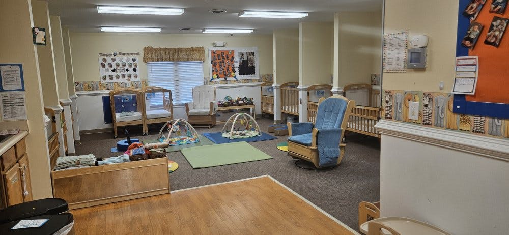 Baby room with cribs, play mats, and rocking chairs