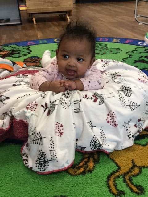 Child on stomach on a blanket on a rug