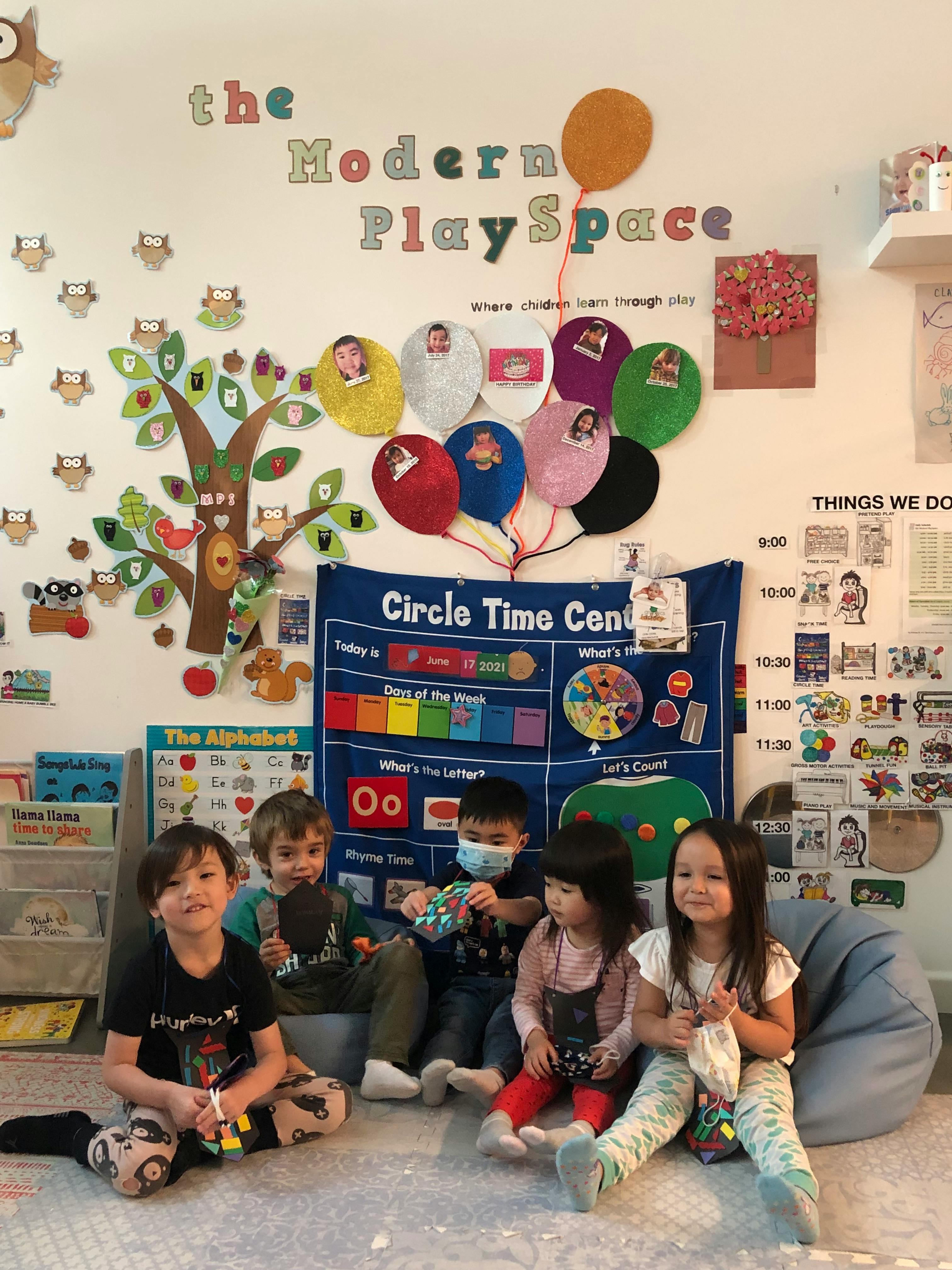Five children sitting on the floor in a classroom