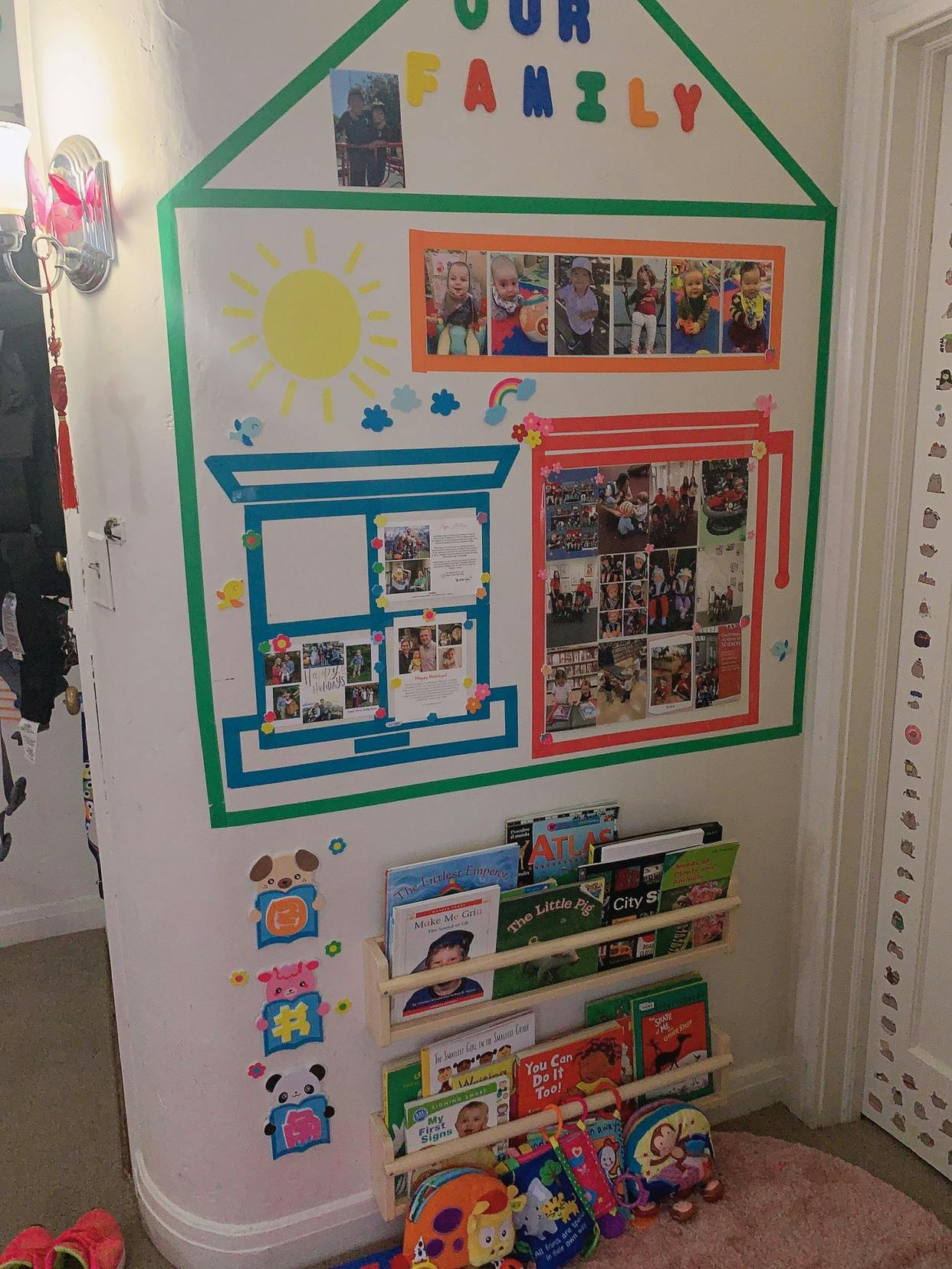 Wall decorated with house outline, photos, and text "OUR FAMILY" above a bookshelf