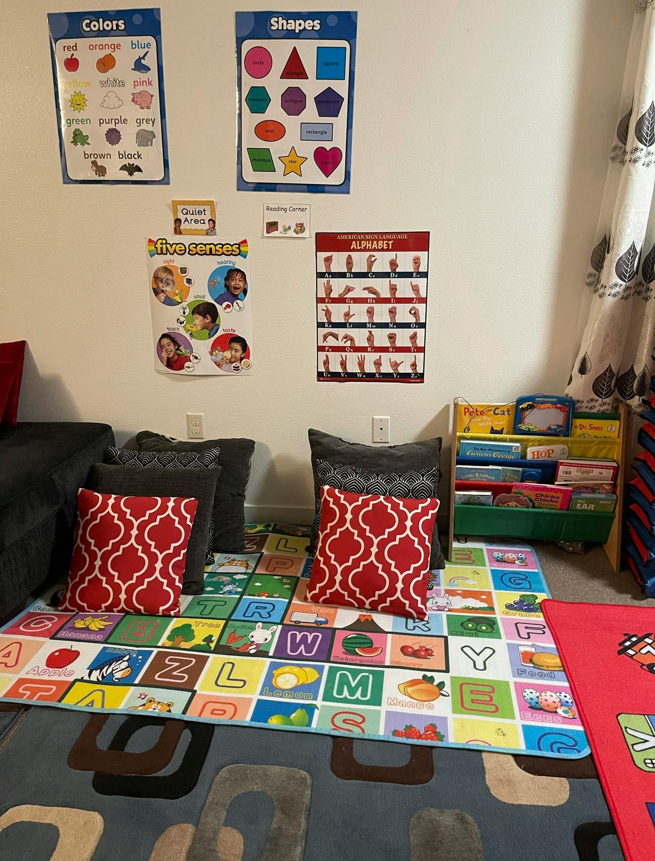 Playroom with alphabet rug, pillows, and educational posters on the wall