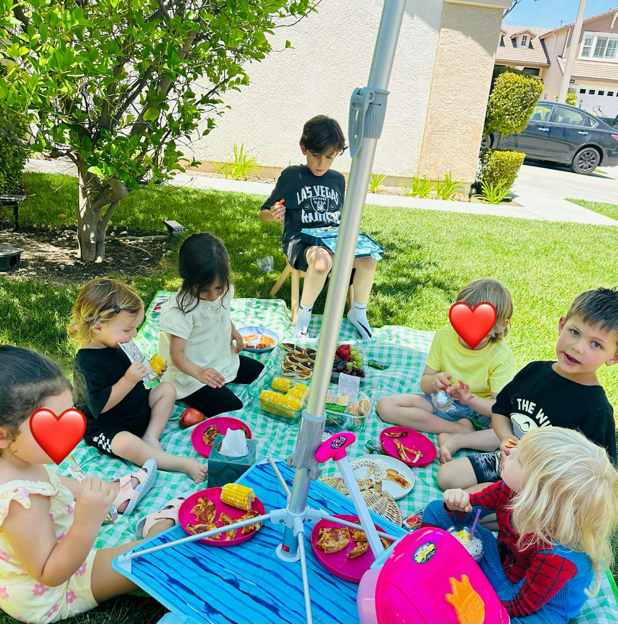 Children sitting on a blanket for a picnic outdoors