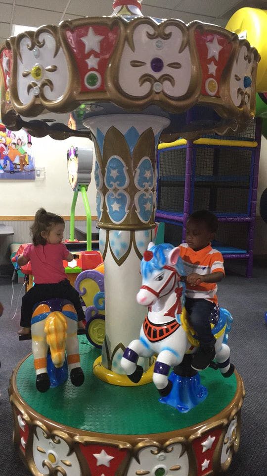 Two children riding on a carousel