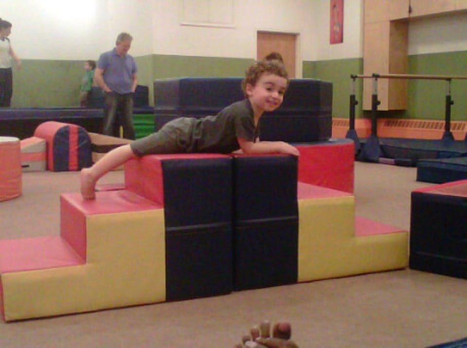 Child lying on a soft play structure