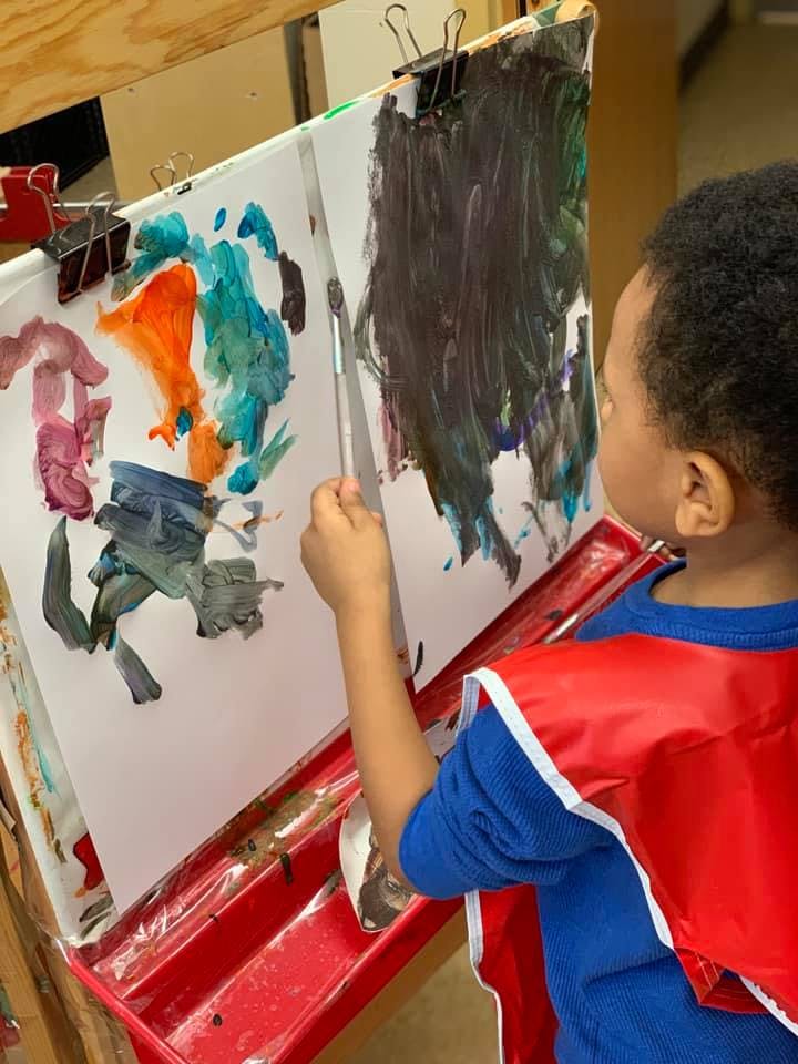 Child painting on an easel