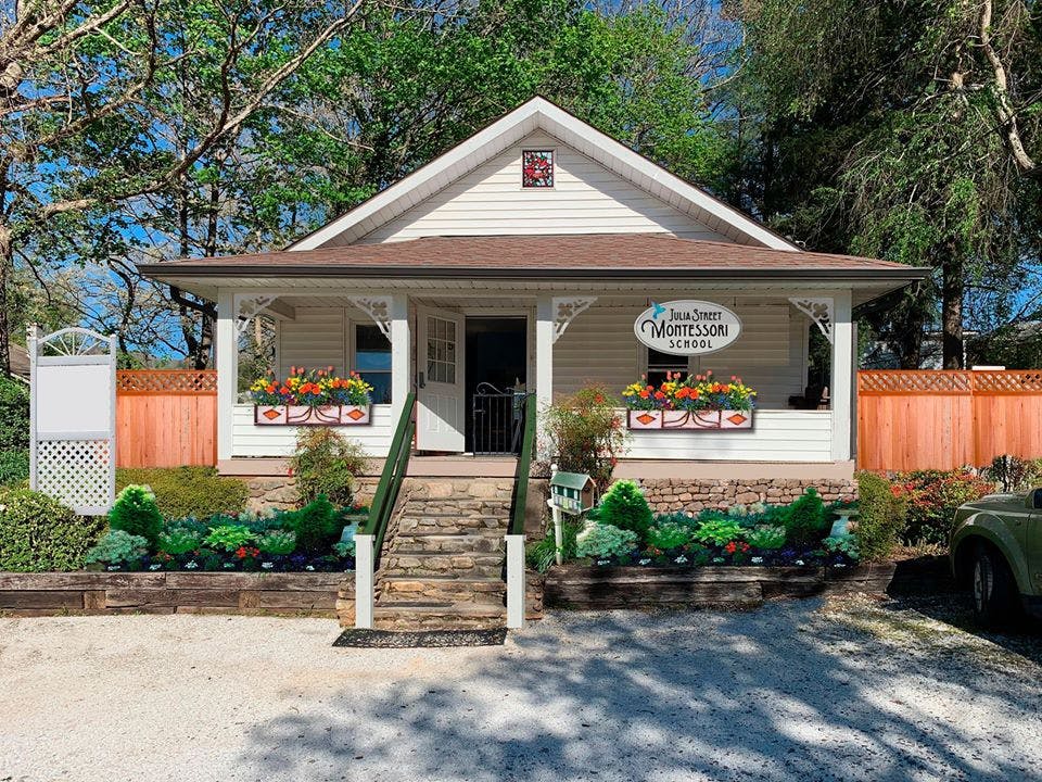 White house with a porch, steps, and flower boxes