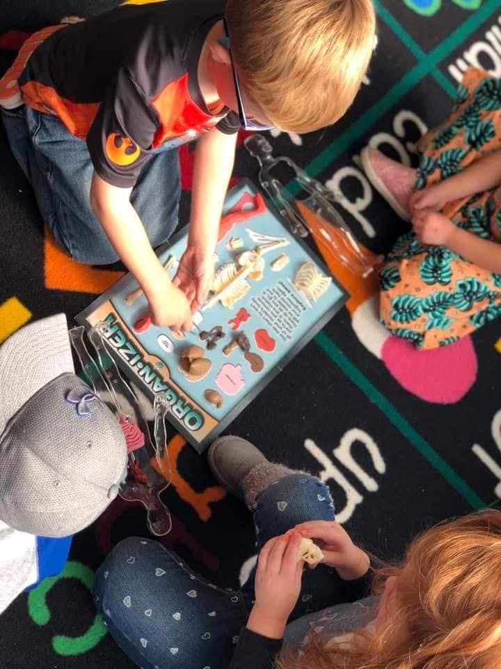Child playing with an organizer board on the floor