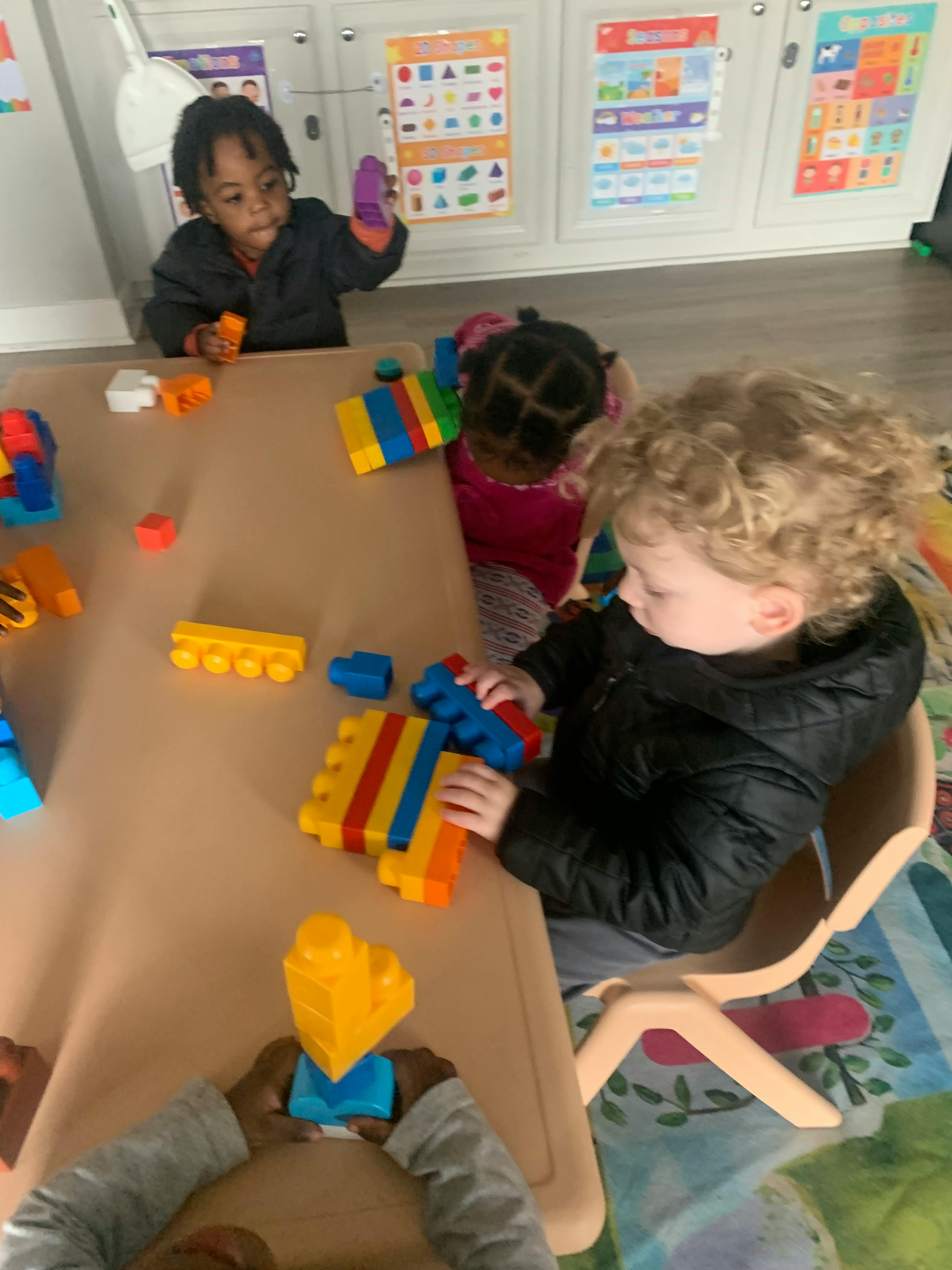 Children playing with colorful building blocks at a table